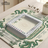 Sage green mahjong mat with a bamboo pattern, dragon design, printed rules around the edge, and a scalloped edge option.