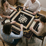 Black and gold square mahjong mat with an art deco crane and floral border, rule reminders around the edges, and a blank center area.