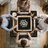 Black and gold square mahjong mat with an art deco crane and floral border, rule reminders around the edges, and a blank center area.