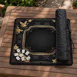 Black and gold square mahjong mat with an art deco crane and floral border, rule reminders around the edges, and a blank center area.