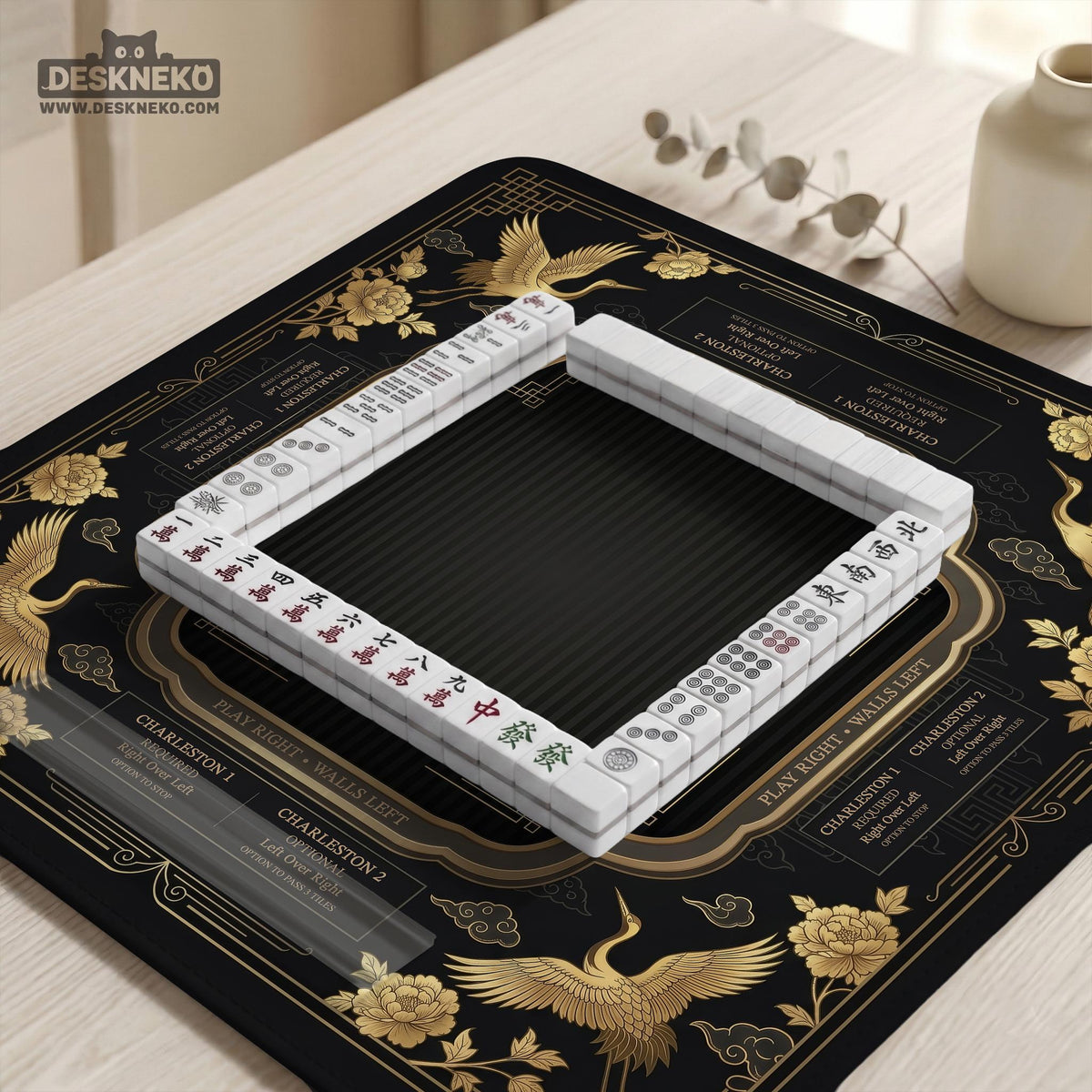 Black and gold square mahjong mat with an art deco crane and floral border, rule reminders around the edges, and a blank center area.