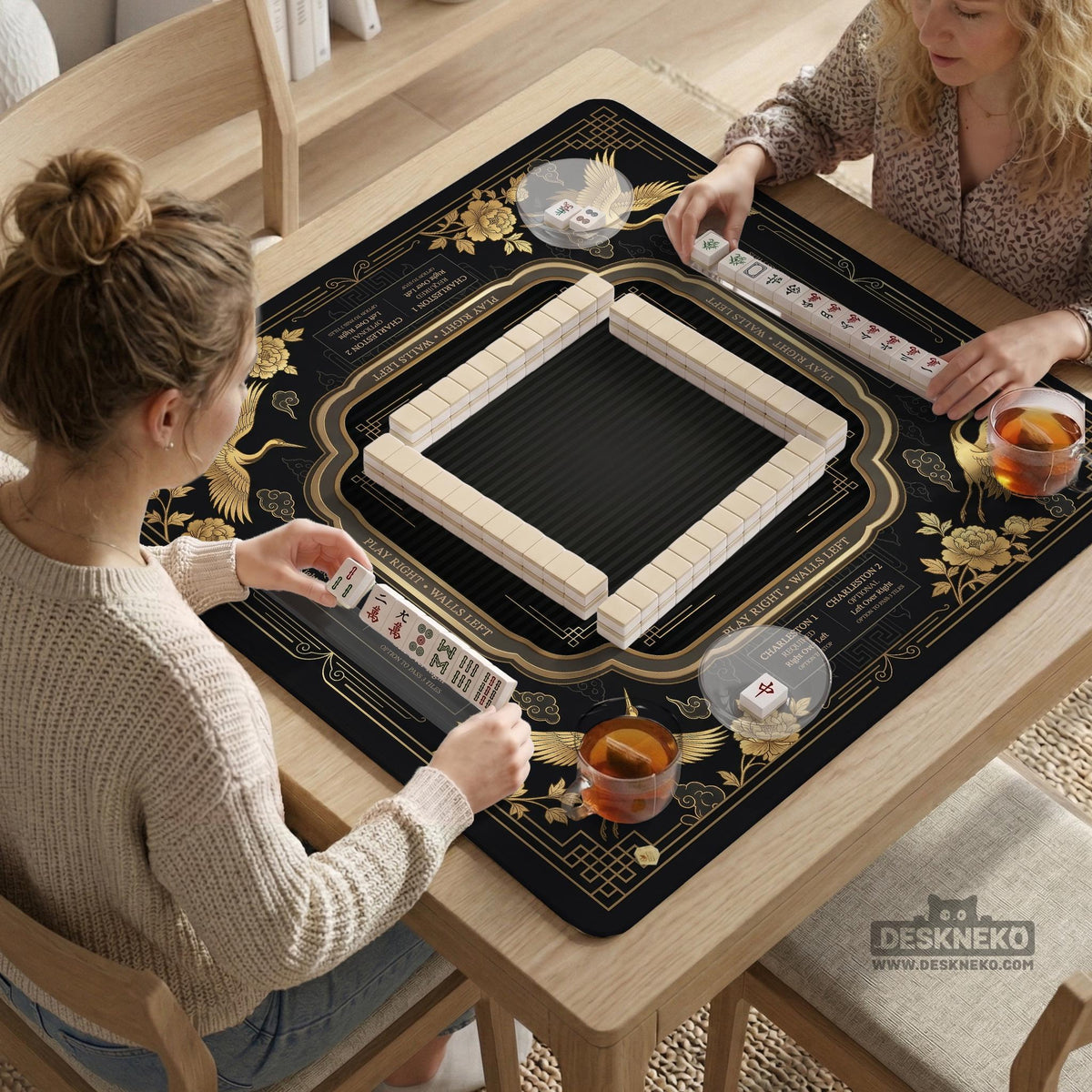 Black and gold square mahjong mat with an art deco crane and floral border, rule reminders around the edges, and a blank center area.