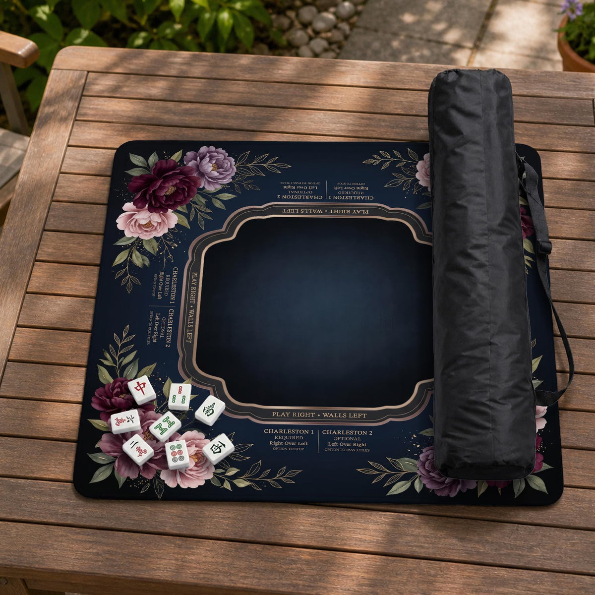Burgundy mahjong mat with a floral border, gold botanical details, and printed American Mahjong rules on a dark background.