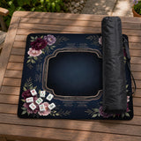 Burgundy mahjong mat with a floral border, gold botanical details, and printed American Mahjong rules on a dark background.