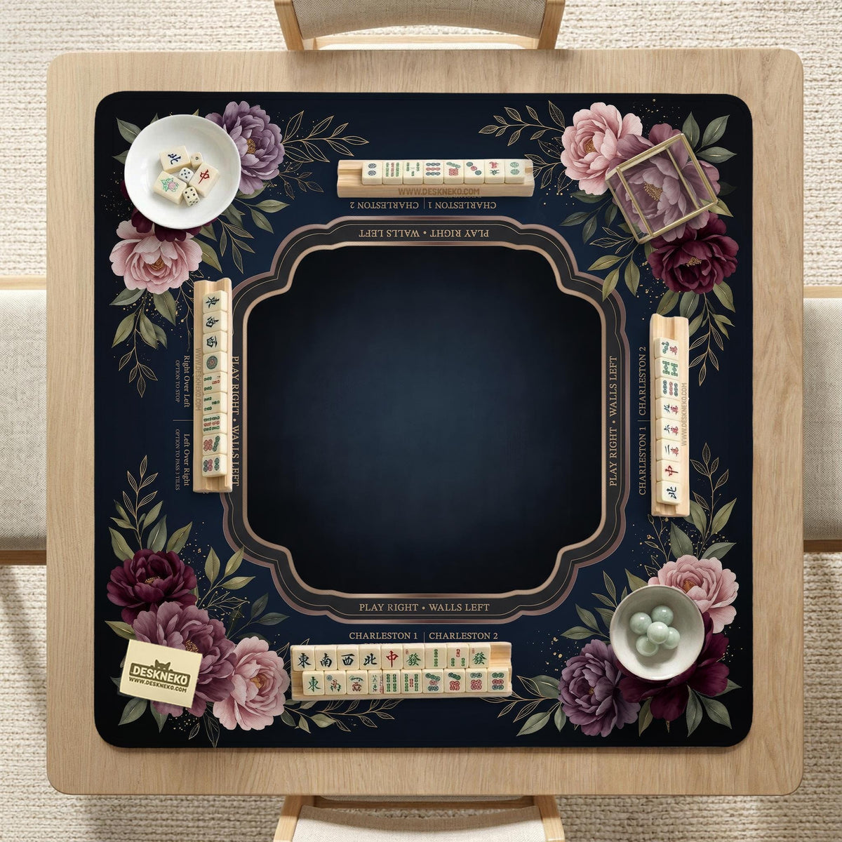 Burgundy mahjong mat with a floral border, gold botanical details, and printed American Mahjong rules on a dark background.