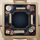 Burgundy mahjong mat with a floral border, gold botanical details, and printed American Mahjong rules on a dark background.