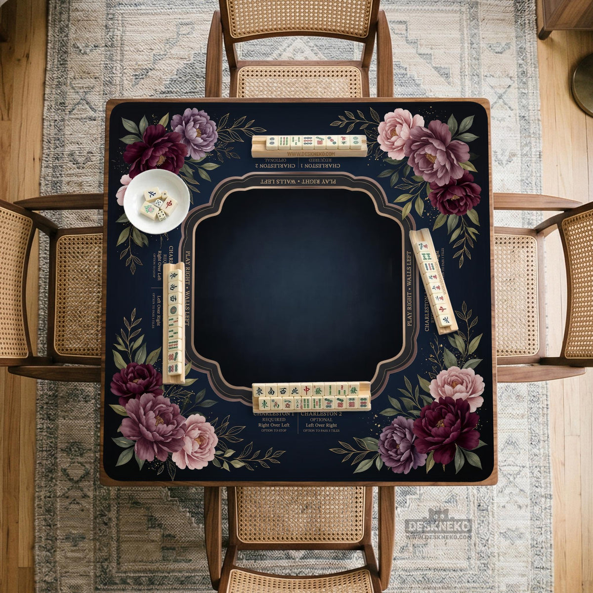 Burgundy mahjong mat with a floral border, gold botanical details, and printed American Mahjong rules on a dark background.