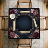 Burgundy mahjong mat with a floral border, gold botanical details, and printed American Mahjong rules on a dark background.