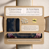 Burgundy mahjong mat with a floral border, gold botanical details, and printed American Mahjong rules on a dark background.