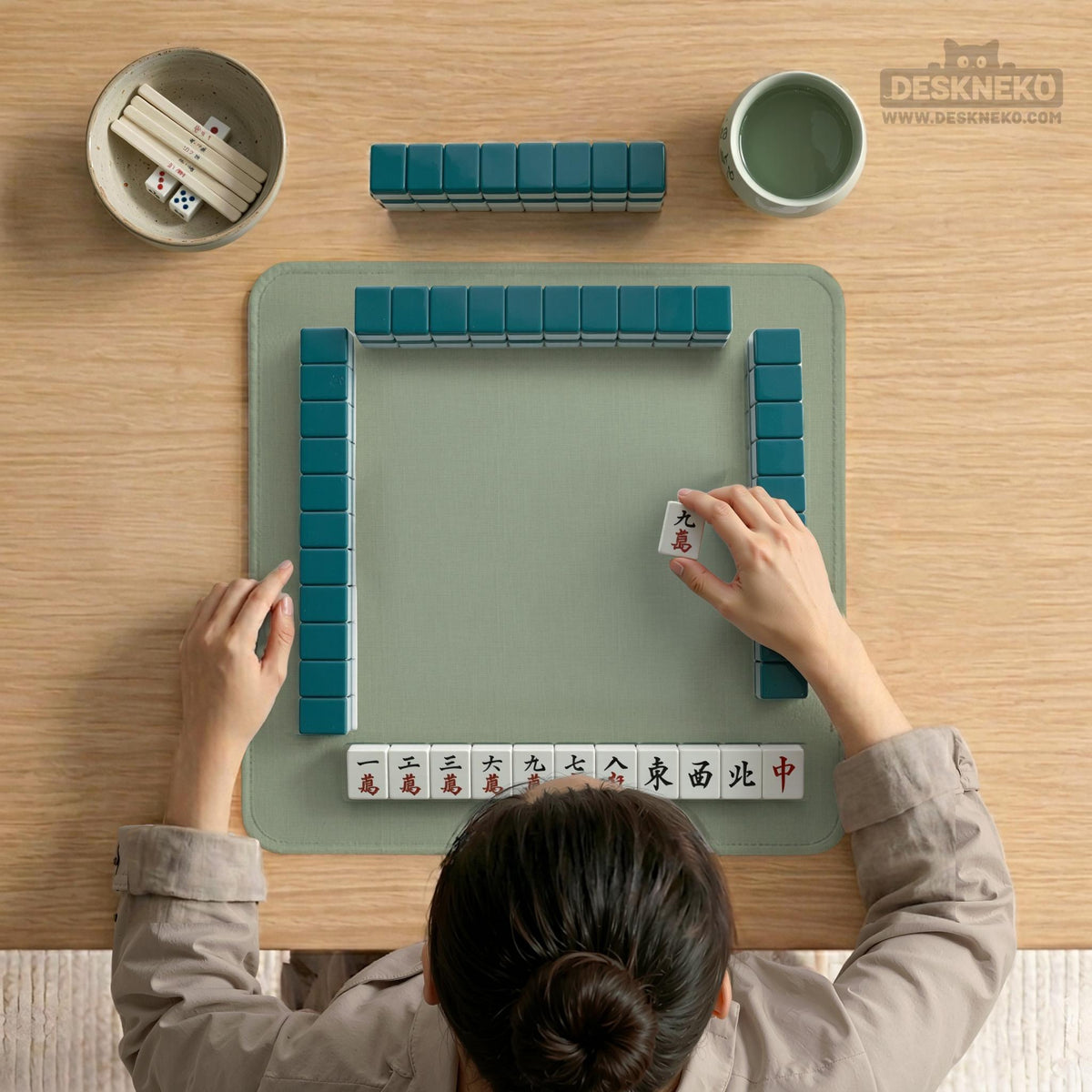 A square sage green mahjong mat with scalloped edges on a plain background.