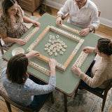 A square sage green mahjong mat with scalloped edges on a plain background.
