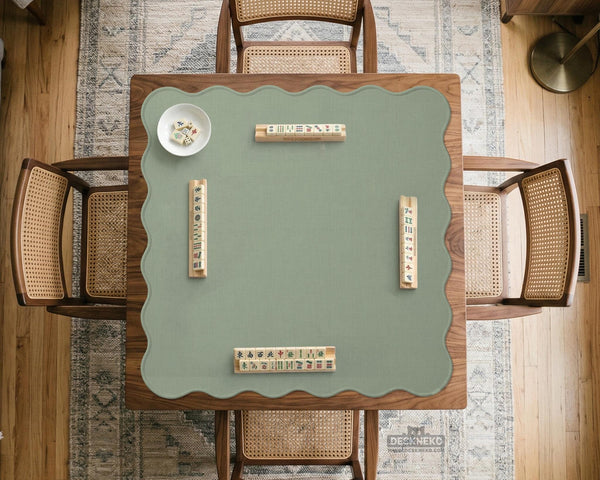 A square sage green mahjong mat with scalloped edges on a plain background.