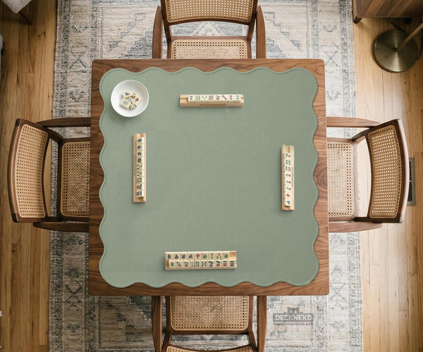 A square sage green mahjong mat with scalloped edges on a plain background.
