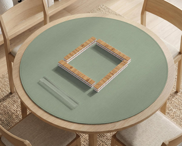 A square sage green mahjong mat with scalloped edges on a plain background.