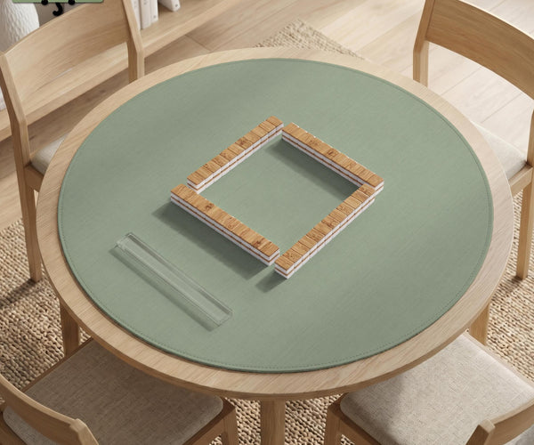 A square sage green mahjong mat with scalloped edges on a plain background.