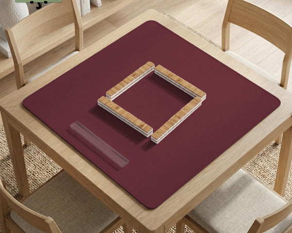 Plain burgundy square mahjong mat with scalloped edges on a white background.