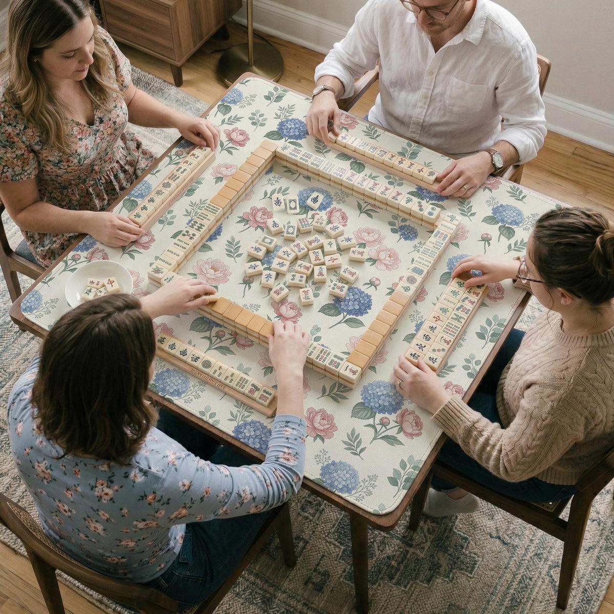 Pink floral mahjong table mat with peonies, blue hydrangeas, sage green leaves, and an ivory background.