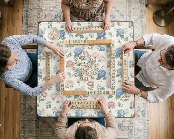Pink floral mahjong table mat with peonies, blue hydrangeas, sage green leaves, and an ivory background.