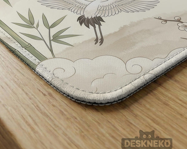 Sage green scalloped mahjong mat with bamboo, crane, and blossom illustration and printed rules around the border.