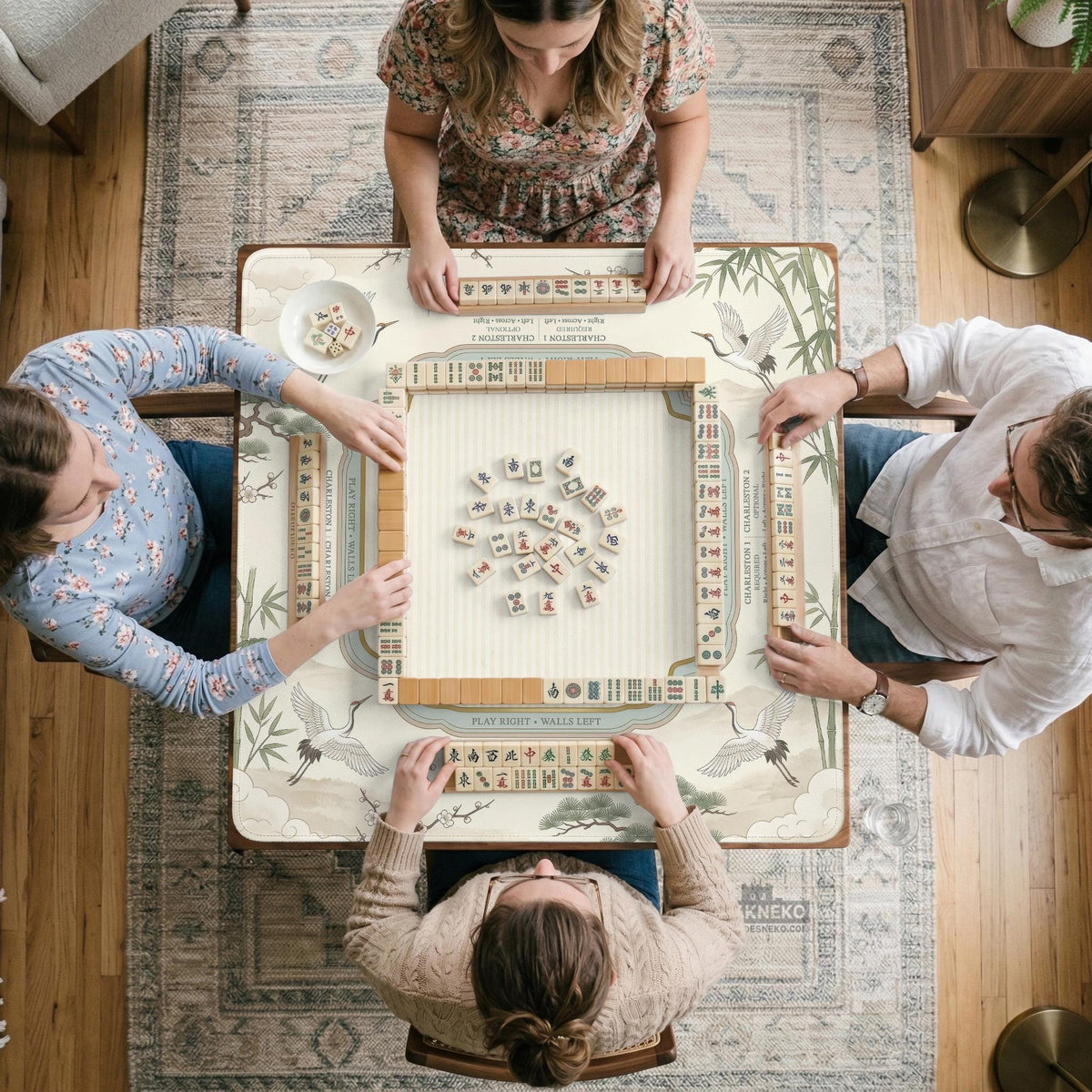 Sage green scalloped mahjong mat with bamboo, crane, and blossom illustration and printed rules around the border.