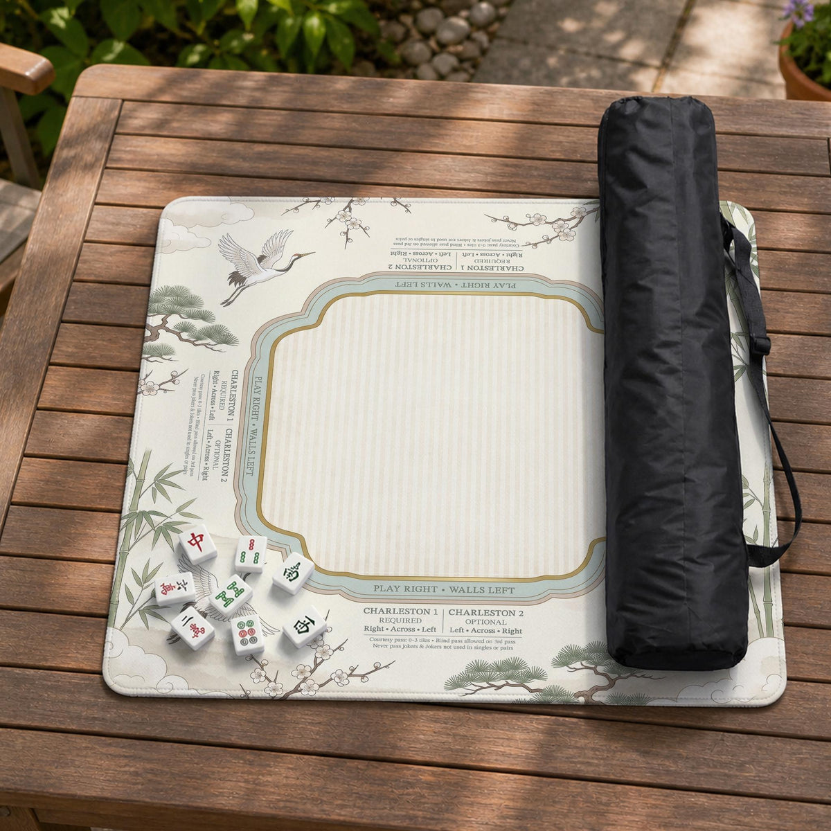 Sage green scalloped mahjong mat with bamboo, crane, and blossom illustration and printed rules around the border.