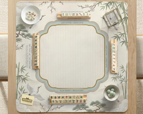 Sage green scalloped mahjong mat with bamboo, crane, and blossom illustration and printed rules around the border.