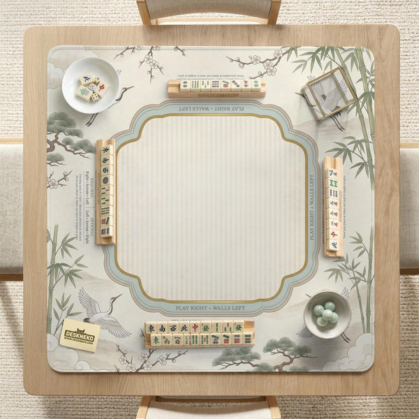 Sage green scalloped mahjong mat with bamboo, crane, and blossom illustration and printed rules around the border.