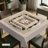 Beige mahjong mat with a botanical floral bird design, blush flowers, olive green leaves, black flower accents, and a warm linen-style background. Scalloped edge option shown.