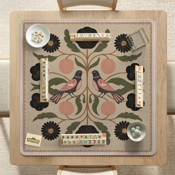 Beige mahjong mat with a botanical floral bird design, blush flowers, olive green leaves, black flower accents, and a warm linen-style background. Scalloped edge option shown.