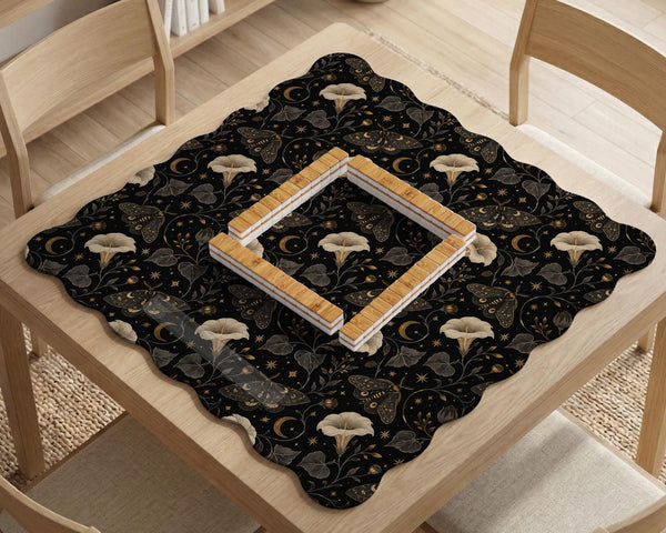 Black square mahjong mat with moths, moonflowers, crescent moons, and scattered stars in a celestial floral pattern.