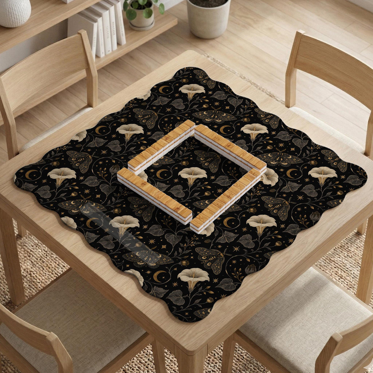 Black square mahjong mat with moths, moonflowers, crescent moons, and scattered stars in a celestial floral pattern.