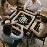 Black square mahjong mat with moths, moonflowers, crescent moons, and scattered stars in a celestial floral pattern.
