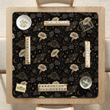 Black square mahjong mat with moths, moonflowers, crescent moons, and scattered stars in a celestial floral pattern.