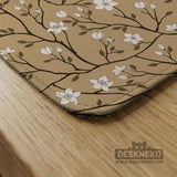 Beige mahjong mat with a white blossom branch floral pattern on a neutral background.