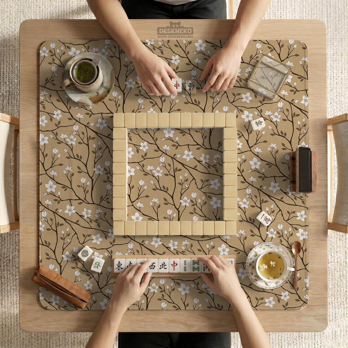 Beige mahjong mat with a white blossom branch floral pattern on a neutral background.