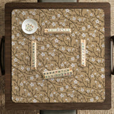 Beige mahjong mat with a white blossom branch floral pattern on a neutral background.