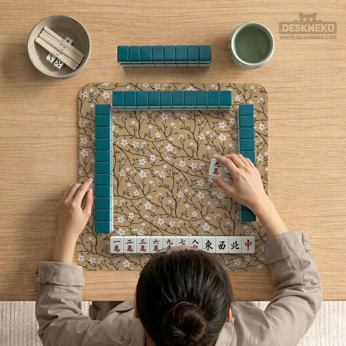 Beige mahjong mat with a white blossom branch floral pattern on a neutral background.