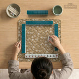 Beige mahjong mat with a white blossom branch floral pattern on a neutral background.
