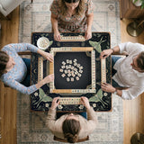 A dark floral mahjong mat with a scalloped edge, moth and flower artwork, and an American Mahjong rules layout on a dark background.