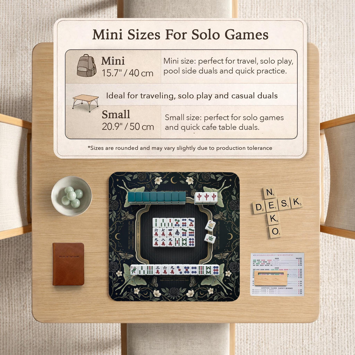 A dark floral mahjong mat with a scalloped edge, moth and flower artwork, and an American Mahjong rules layout on a dark background.