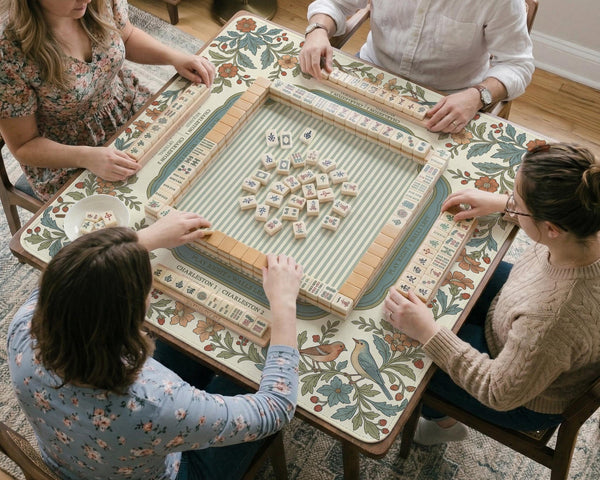 Square mahjong mat with a cream background, blue birds, sage leaves, terracotta flowers, and a decorative botanical border with printed rules text.