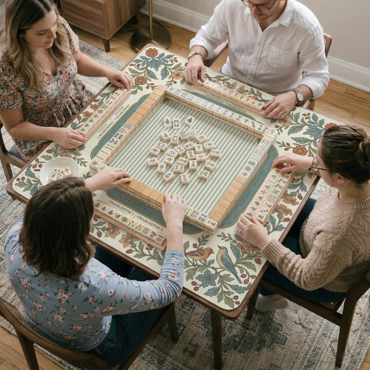 Square mahjong mat with a cream background, blue birds, sage leaves, terracotta flowers, and a decorative botanical border with printed rules text.