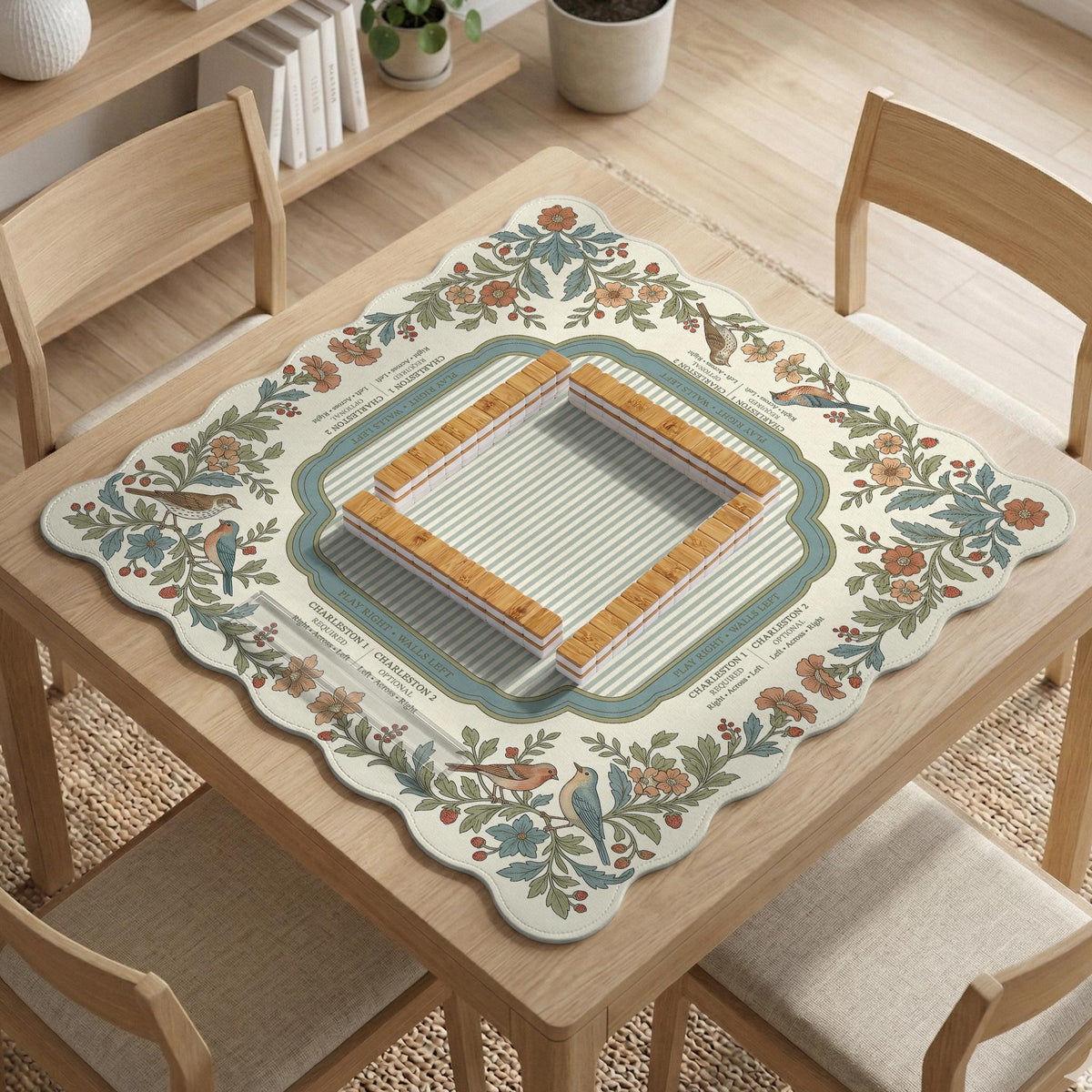 Square mahjong mat with a cream background, blue birds, sage leaves, terracotta flowers, and a decorative botanical border with printed rules text.