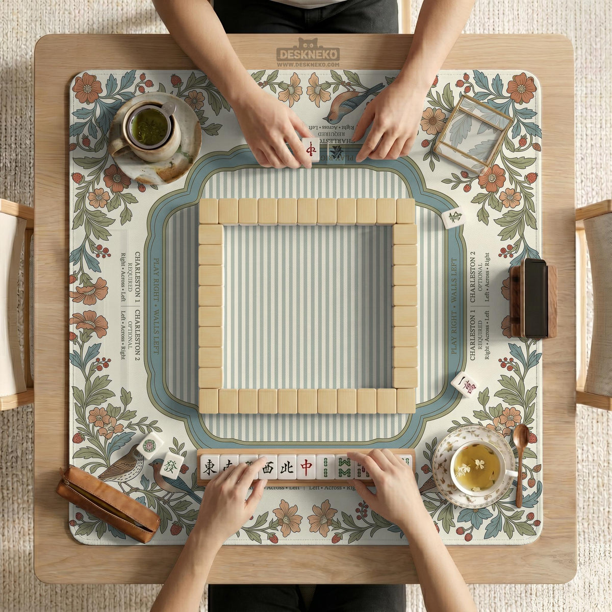 Square mahjong mat with a cream background, blue birds, sage leaves, terracotta flowers, and a decorative botanical border with printed rules text.