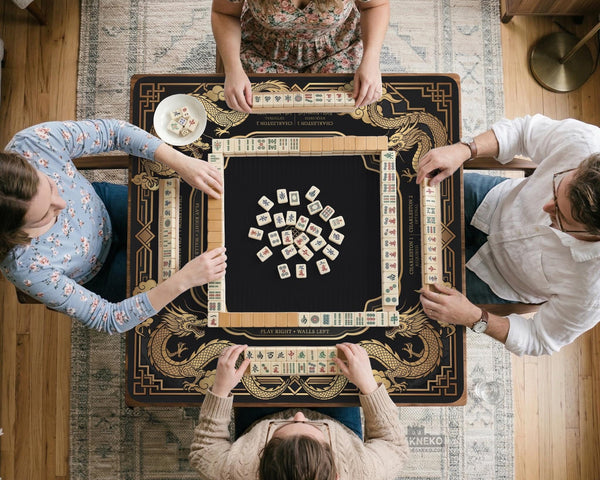 Black mahjong mat with gold dragon artwork, a scalloped edge, and printed Mahjong rules on the surface.