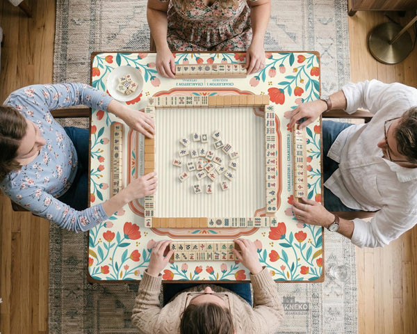 Cream mahjong mat with a coral and teal floral border, rule layout text, Charleston guide notes, and a blank center area for tile play.