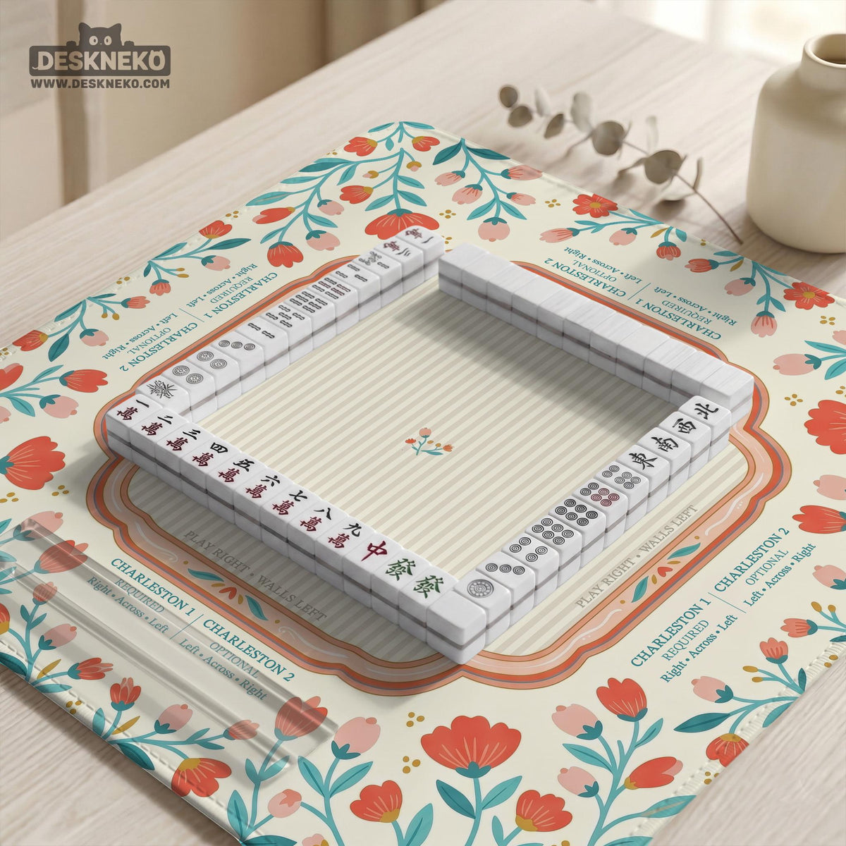 Cream mahjong mat with a coral and teal floral border, rule layout text, Charleston guide notes, and a blank center area for tile play.