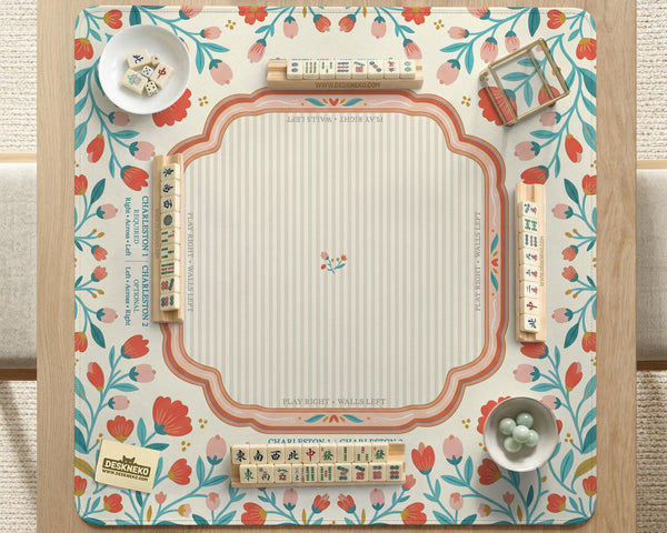 Cream mahjong mat with a coral and teal floral border, rule layout text, Charleston guide notes, and a blank center area for tile play.