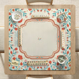 Cream mahjong mat with a coral and teal floral border, rule layout text, Charleston guide notes, and a blank center area for tile play.