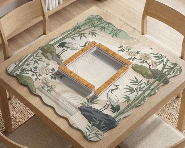 Square mahjong mat with a cream background, sage green cranes, bamboo leaves, peony branches, stones, and thin linework.
